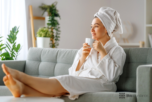 woman in robe sitting on couch